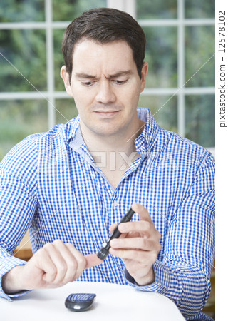 Man Checking Blood Sugar Level At Home 12578102