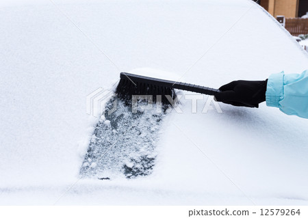 Woman cleaning snow from the car Woman cleaning snow from the car 12579264