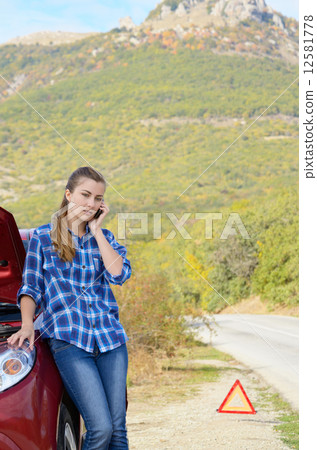 Young woman near broken car speaking by phone Young woman near broken car speaking by phone 12581778