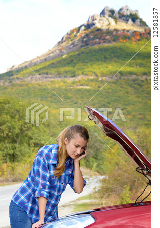 Young woman near broken car speaking by phone Young woman near broken car speaking by phone 12581857