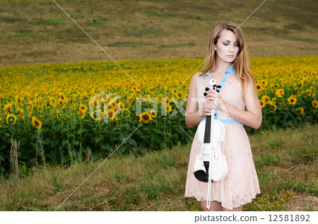 Woman stands with vilolin by country road Woman stands with vilolin by country road 12581892