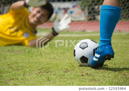 Attack soccer player shooting to defense team 12583964