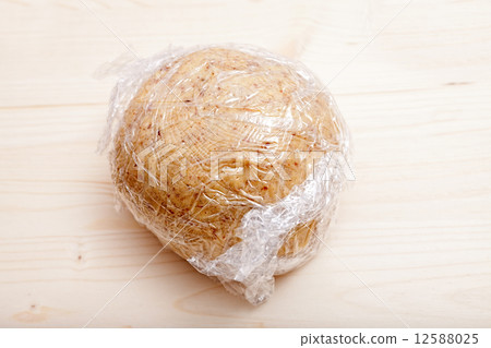 Ready shaped dough ball wrapped in plastic wrap 12588025