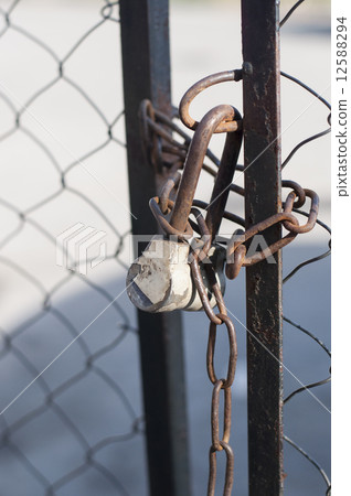 Chain link fence and metal door with lock 12588294