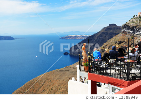 The view on Fira town and tourists enjoying their vacation, Greece The view on Fira town and tourists enjoying their vacation, Greece 12588949
