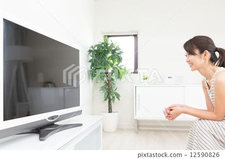 A woman watching TV 12590826