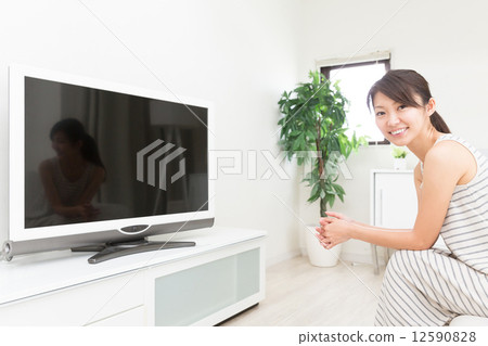 A woman watching TV A woman watching TV 12590828