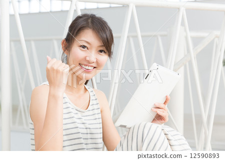 觀看一種片劑的婦女在屋子裡 觀看一種片劑的婦女在屋子裡 12590893