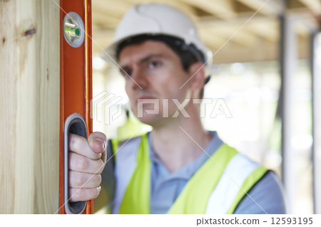 Builder Checking Work With Spirit Level 12593195