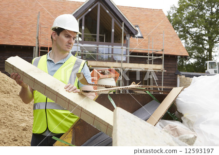 Builder Putting Waste Into Rubbish Skip 12593197