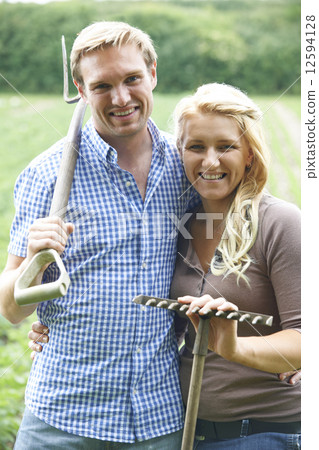Couple Working In Field On Organic Farm 12594128