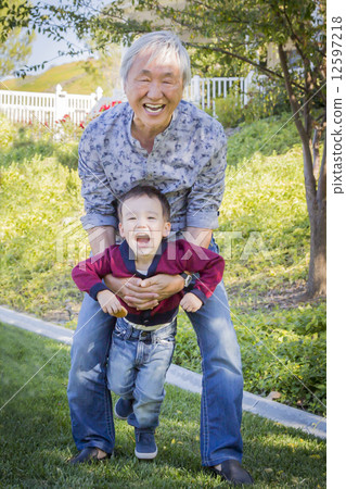 Chinese Grandpa Having Fun with His Mixed Race Grandson Outside Chinese Grandpa Having Fun with His Mixed Race Grandson Outside 12597218