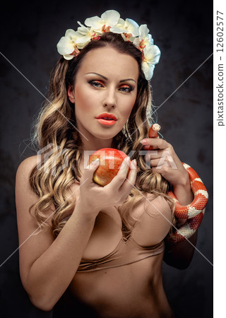 Sexy beautiful woman with red apple and snake, conceptual photo 12602577