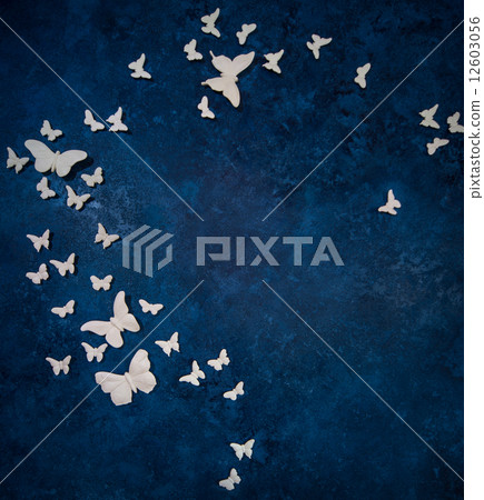 White small and big artificial butterflies over dark blue backgr White small and big artificial butterflies over dark blue backgr 12603056