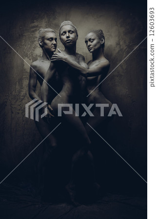 Naked sportive women painted in grey color posing over grey wall 12603693