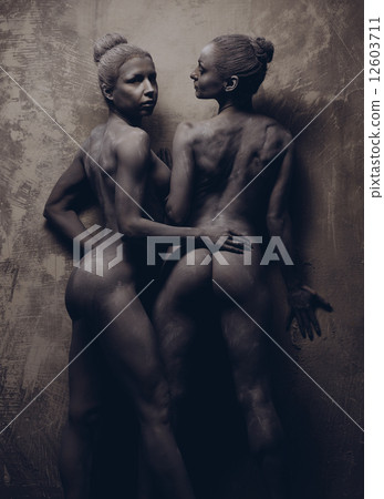 Naked sportive women painted in grey color posing over grey wall Naked sportive women painted in grey color posing over grey wall 12603711