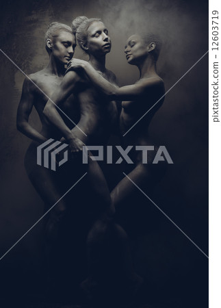 Naked sportive women painted in grey color posing over grey wall Naked sportive women painted in grey color posing over grey wall 12603719