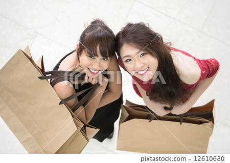 Top down view of two young chinese shopaholic with shopping bags Top down view of two young chinese shopaholic with shopping bags 12610680