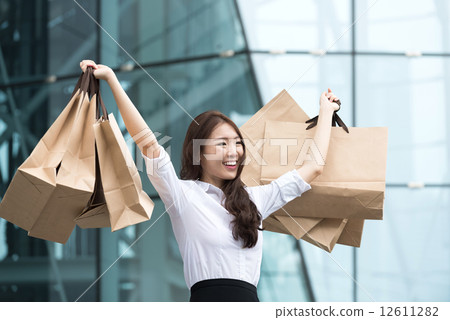 One young chinese office lady shopaholic showing off her shopping buys 12611282