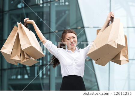 One young chinese office lady shopaholic showing off her shopping buys 12611285