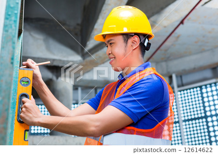 Builder or worker controlling wall on construction site 12614622