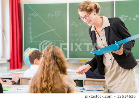 Teacher  teaching a class of  pupils in school 12614626