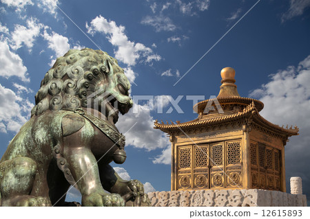 Bronze Guardian Lion Statue and bronze pagoda in the Forbidden City, Beijing, China 12615893