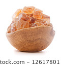 Brown cane caramelized lump sugar in wooden bowl isolated on whi 12617801
