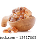 Brown cane caramelized lump sugar in wooden bowl isolated on whi 12617803