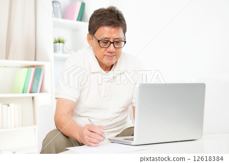 Mature Asian man using computer Mature Asian man using computer 12618384