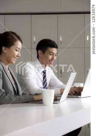 Business people using laptop in office Business people using laptop in office 12618974