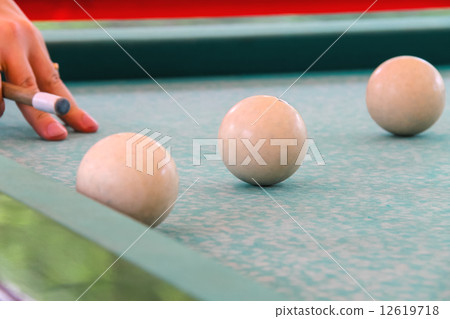 Hand with cue before the a blow to the billiard ball 12619718