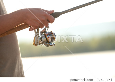 Modern clean fishing rod in hands 12620761