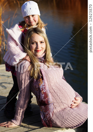 Little girl with her mother on the autumn lake Little girl with her mother on the autumn lake 12623870