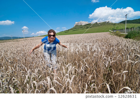 Young woman in wheat field, back is Spis castle Young woman in wheat field, back is Spis castle 12628631