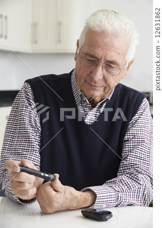 Senior Man Checking Blood Sugar Level At Home 12631862