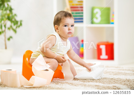 kid boy sitting on chamber pot with toilet paper kid boy sitting on chamber pot with toilet paper 12635835