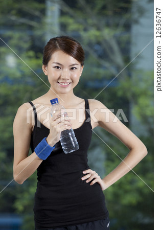 Fit Asian woman holding water bottle  12636747