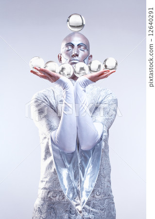 Magician with Glass Balls in Stage Makeup and Costume 12640291