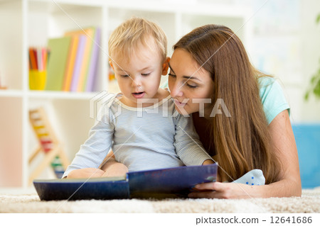 mother reads a book to kid at home mother reads a book to kid at home 12641686