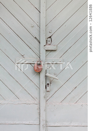 green wooden door with a padlock 12641886