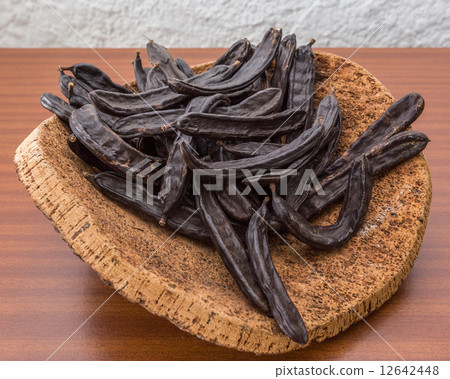 Carob pods on cortical stand. On the table. 12642448