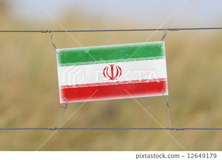 Border fence - Old plastic sign with a flag 12649179