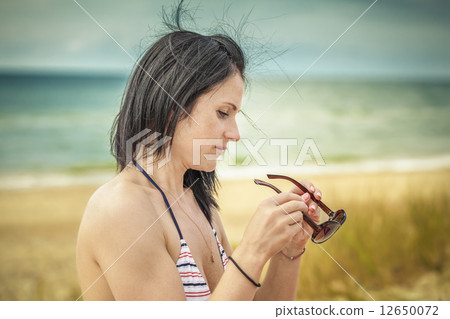 Woman with sunglasses at the sea  12650072