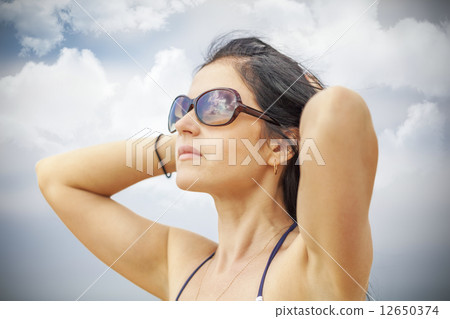 Woman keep the hair on the cloudy sky background  12650374