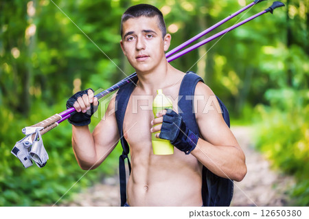 Teenager with water bottle and walking sticks  12650380