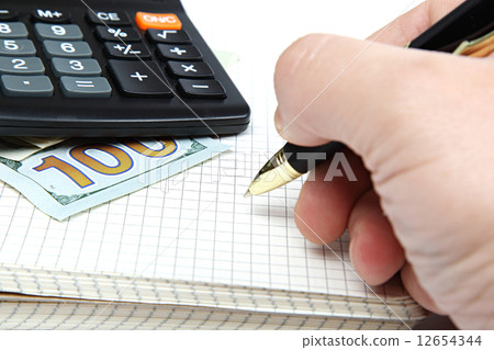 Hand with pen and money, calculator, notepad. 12654344