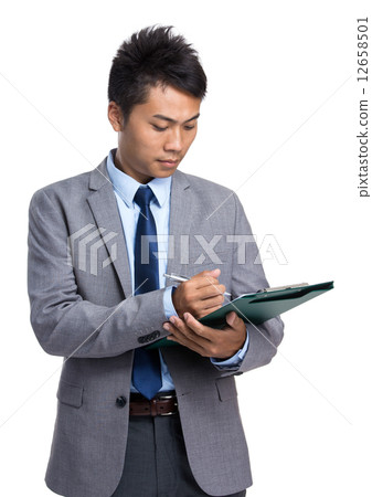 Asian businessman write on clipboard Asian businessman write on clipboard 12658501