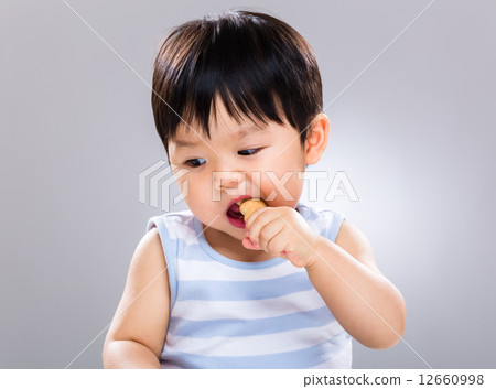 Baby boy having biscuit 12660998
