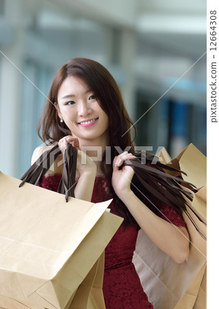 One young pretty woman in red with shopping bags inside the mall One young pretty woman in red with shopping bags inside the mall 12664308